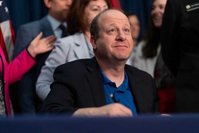 A government official seated at a table during a signing ceremony
