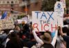 Crowd of protesters holding signs advocating for tax reform