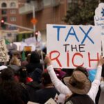 Crowd of protesters holding signs advocating for tax reform