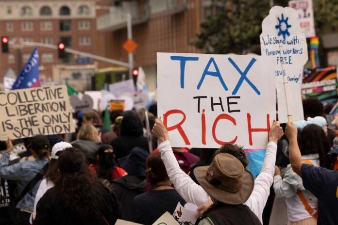 Crowd of protesters holding signs advocating for tax reform