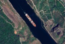 Shocking Policy Shift: UK Reopens Russian Fuel Door Aerial view of a cargo ship navigating a river surrounded by greenery
