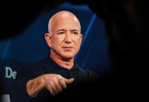 Bald man in a black shirt speaking on stage