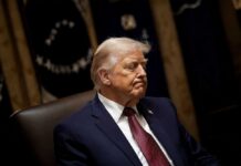 Trump Declared Healthy—Critics Want More Answers A political figure seated with a serious expression in a formal setting