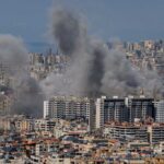 Smoke rising from buildings in a densely populated urban area