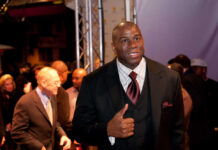 A man in a suit giving a thumbs up at a red carpet event