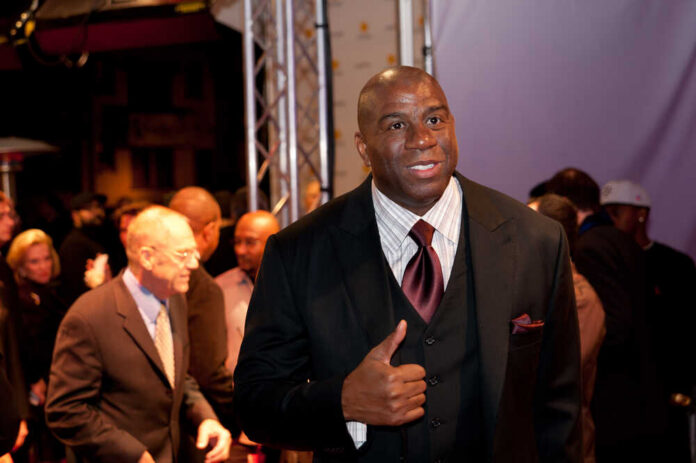 A man in a suit giving a thumbs up at a red carpet event