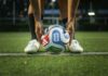 Soccer player placing a ball on a field