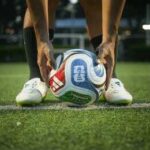 Soccer player placing a ball on a field