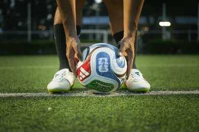 Soccer player placing a ball on a field