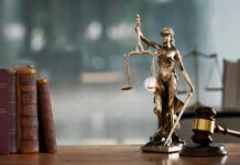 Court Draws Hard Line Around Fed A bronze statue of Lady Justice holding scales and a sword, with law books and a gavel in the foreground