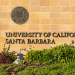University entrance sign with seal and landscaping