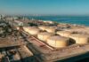 Gas Prices Ease As Peace Talks Advance Aerial view of large oil storage tanks near a coastal area