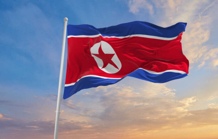 Large,North,Korea,Flag,Waving,In,The,Wind North Korean flag waving against a blue sky