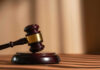 Behind Closed Doors: Killer Avoids Execution A wooden gavel resting on a circular base with soft lighting