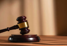 Behind Closed Doors: Killer Avoids Execution A wooden gavel resting on a circular base with soft lighting