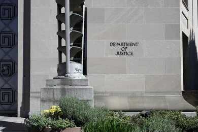 Facade of a government building featuring the American flag and decorative entrance