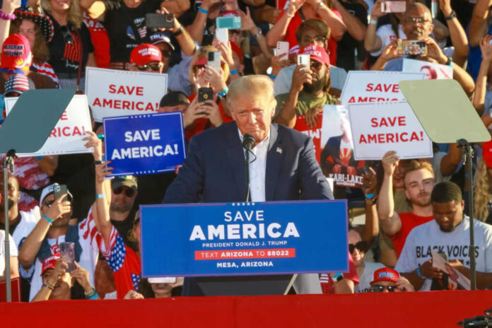 shutterstock_2212426127 Donald Trump speaking at a political rally with supporters holding signs