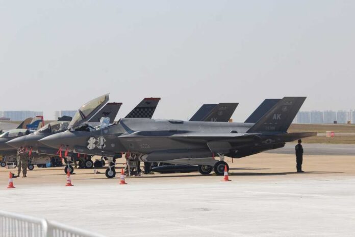 F-35 military jets parked on an airfield with crew members nearby