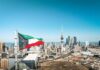 Kuwait Hit, Competing Narratives Take Over Kuwait flag waving over a city skyline with modern buildings