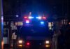 Emergency vehicle with flashing lights in a busy urban area at night