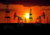 Hormuz Hopes Slam Prices — Risk Still Lurks Silhouetted oil rigs against a vibrant sunset