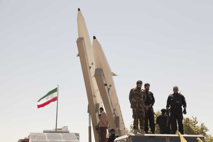 Quds,Day,Rally,,Display,Middleware,Missiles,,Zulfiqar,Rocket,,Iranian,Revolutionary Military personnel standing near missile launchers with an Iranian flag in the background