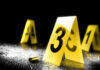 Pool Day Horror Leaves Children Wounded Yellow evidence markers with numbers at a crime scene alongside a bullet casing