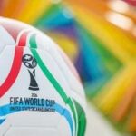 Soccer ball with World Cup logo against a colorful background