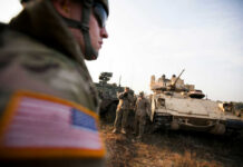 Rubio Quietly Blocked Europe Troop Cuts Soldiers in military gear coordinating near armored vehicles during training
