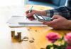 person using calculator with coins on table