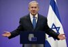 Netanyahu Says New York Trip Is On man in suit speaking at a podium with Israeli flag