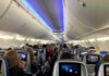 Seat Swap Showdown Stuns Packed Cabin Airplane cabin with passengers seated and seatback screens