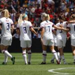 women's soccer team celebrating on the field