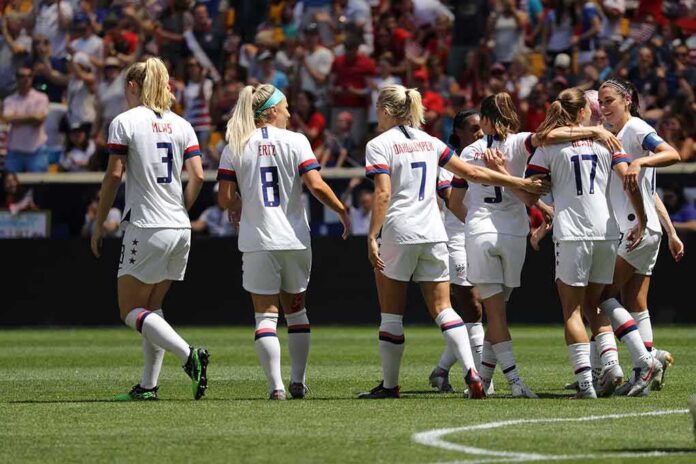 shutterstock_1419232265 women's soccer team celebrating on the field