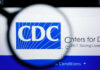 CDC Officials Allege Political Interference Magnifying glass focusing on the CDC logo on a computer screen