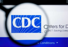 CDC Officials Allege Political Interference Magnifying glass focusing on the CDC logo on a computer screen