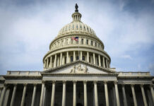 Congress Weighs $1.5T Defense Plan The U.S. Capitol building with an American flag flying in front