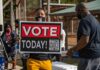 Michigan Senator’s Secret Vote Claim Person holding a large voting sign at an outdoor event