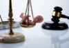 Army Captain Jailed For Secret Abortion Scales of justice with a baby figurine and a gavel in the background