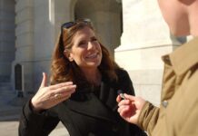 Woman being interviewed outside a stone building