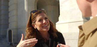 Woman being interviewed outside a stone building