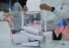 Declassified Stunner Rattles 2026 Person casting a vote into a transparent ballot box during an election