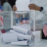 Declassified Stunner Rattles 2026 Person casting a vote into a transparent ballot box during an election