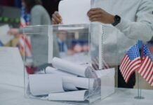 Declassified Stunner Rattles 2026 Person casting a vote into a transparent ballot box during an election