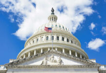 Trump Challenges Citizenship Ruling Again The U.S. Capitol building with an American flag flying in front against a blue sky