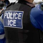 Republicans Clash Over ICE Traffic Stops Close-up of a police officer's vest with 'POLICE ICE' label