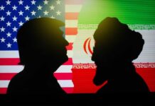 Fresh Trouble For Iran Talks Silhouettes of two figures against the backgrounds of the American and Iranian flags