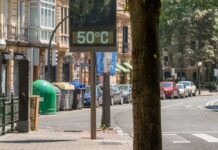 Thousands Die During German Heatwave A thermometer held against a sunset city skyline