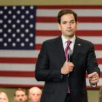 man in suit speaking into a microphone