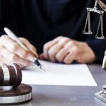 Epstein-Style Deal Shadows Texas Power Judge writing at desk with gavel and Lady Justice statue